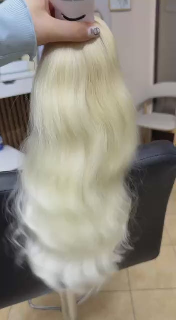 Video showing the flexibility and shine of a 35 cm (14 inch) premium raw Slavic wavy hair extension in cold-bleached blonde color