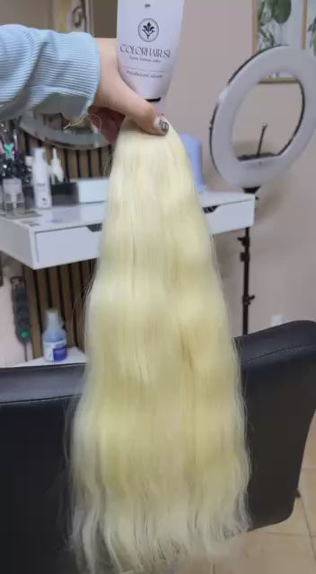 Video showing the flexibility and shine of a 50 cm (20 inch) premium raw Slavic wavy hair extension in cold-bleached blonde color