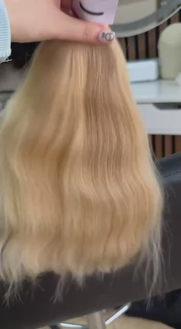 Video showing the flexibility and shine of a 40 cm (16 inch) premium raw Slavic wavy hair extension in cold-bleached Honey Blonde color