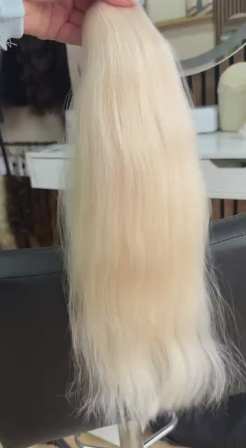 Video showing the flexibility and shine of a 50 cm (20 inch) premium raw Slavic wavy hair extension in cold-bleached blonde color