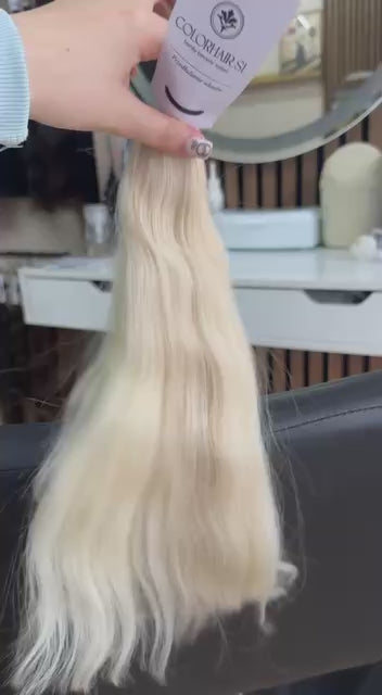 Video showing the flexibility and shine of a 40 cm (16 inch) premium raw Slavic wavy hair extension in cold-bleached blonde color