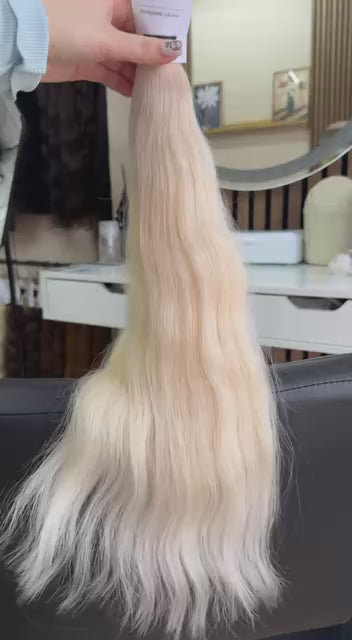 Video showing the flexibility and shine of a 50 cm (20 inch) premium raw Slavic wavy hair extension in cold-bleached blonde color