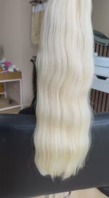 Video showing the flexibility and shine of a 50 cm (20 inch) premium raw Slavic wavy hair extension in cold-bleached blonde color