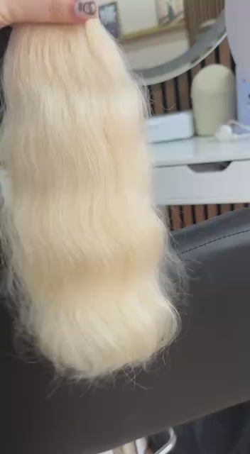 Video showing the flexibility and shine of a 35 cm (14 inch) premium raw Slavic wavy hair extension in cold-bleached blonde color