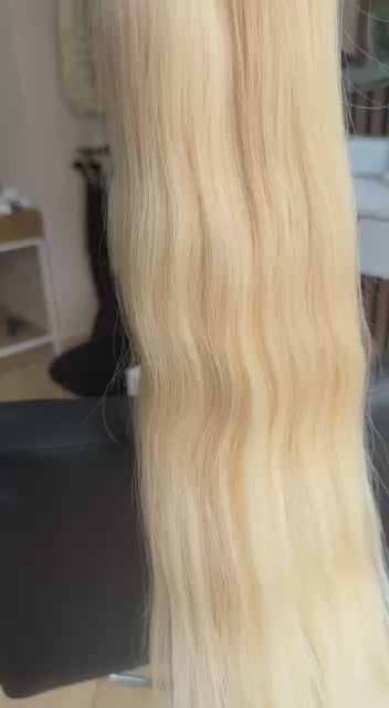Video showing the flexibility and shine of a 50 cm (20 inch) premium raw Slavic wavy hair extension in cold-bleached Honey Blonde color