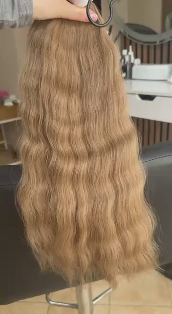 Video showing the flexibility and shine of a 50 cm (20 inch) premium raw Slavic wavy hair extension in cold-bleached Honey Blonde color