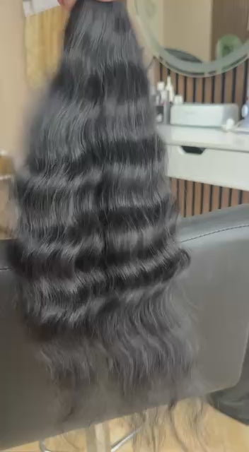 Video showing the flexibility and shine of a 45 cm (18 inch) premium raw Slavic wavy hair extension in cold-bleached black color