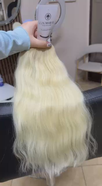 Video showing the flexibility and shine of a 45 cm (18 inch) premium raw Slavic wavy hair extension in cold-bleached Blonde color