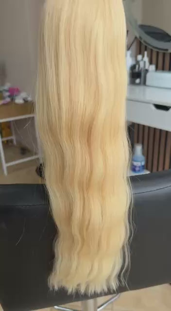 Video showing the flexibility and shine of a 55 cm (22 inch) premium raw Slavic wavy hair extension in cold-bleached Honey Blonde color