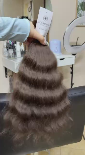 Video showing the flexibility and shine of a 40 cm (16 inch) premium raw Slavic wavy hair extension in cold-bleached black color