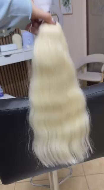 Video showing the flexibility and shine of a 40 cm (16 inch) premium raw Slavic wavy hair extension in cold-bleached blonde color