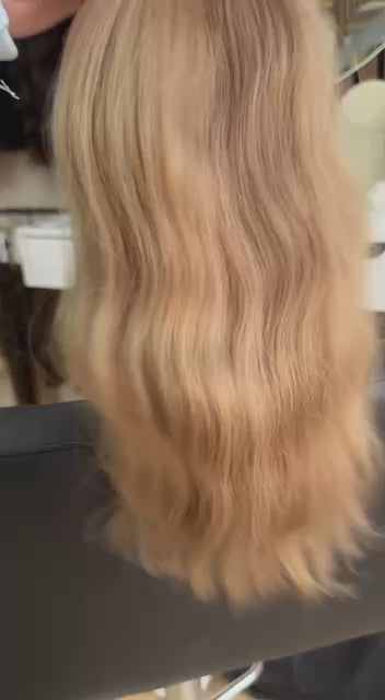 Video showing the flexibility and shine of a 40 cm (16 inch) premium raw Slavic wavy hair extension in cold-bleached Honey Blonde color
