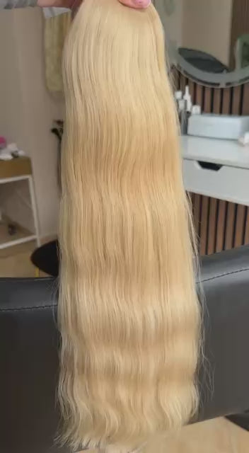 Video showing the flexibility and shine of a 55 cm (22 inch) premium raw Slavic wavy hair extension in cold-bleached Honey Blonde color
