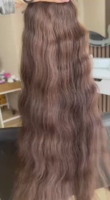 Video showing the flexibility and shine of a 55 cm (22 inch) premium raw Slavic wavy hair extension in cold-bleached brown color