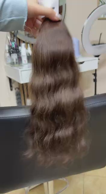 Video showing the flexibility and shine of a 45 cm (18 inch) premium raw Slavic wavy hair extension in cold-bleached Brown color