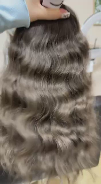 Video showing the flexibility and shine of a 40 cm (16 inch) premium raw Slavic wavy hair extension in cold-bleached black color