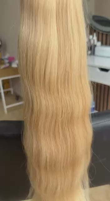 Video showing the flexibility and shine of a 55 cm (22 inch) premium raw Slavic wavy hair extension in cold-bleached Honey Blonde color