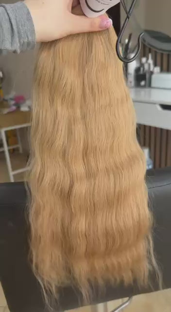 Video showing the flexibility and shine of a 50 cm (20 inch) premium raw Slavic wavy hair extension in cold-bleached Honey Blonde color