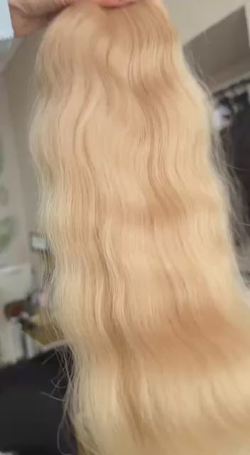 Video showing the flexibility and shine of a 45 cm (18 inch) premium raw Slavic wavy hair extension in cold-bleached Honey Blonde color