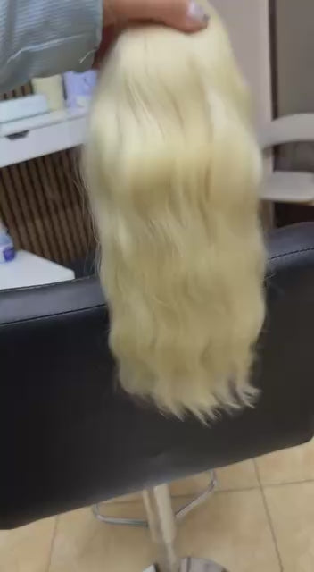 Video showing the flexibility and shine of a 35 cm (14 inch) premium raw Slavic wavy hair extension in cold-bleached blonde color