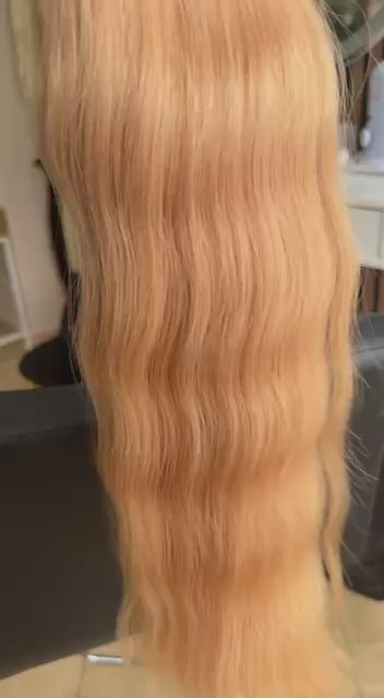 Video showing the flexibility and shine of a 50 cm (20 inch) premium raw Slavic wavy hair extension in cold-bleached Honey Blonde color