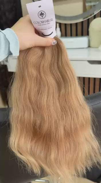 Video showing the flexibility and shine of a 40 cm (16 inch) premium raw Slavic wavy hair extension in cold-bleached Honey Blonde color