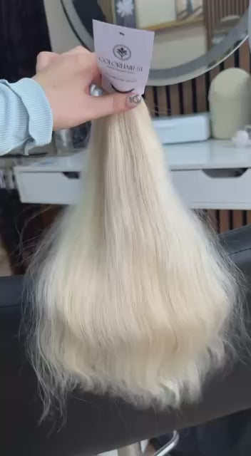Video showing the flexibility and shine of a 40 cm (16 inch) premium raw Slavic wavy hair extension in cold-bleached blonde color